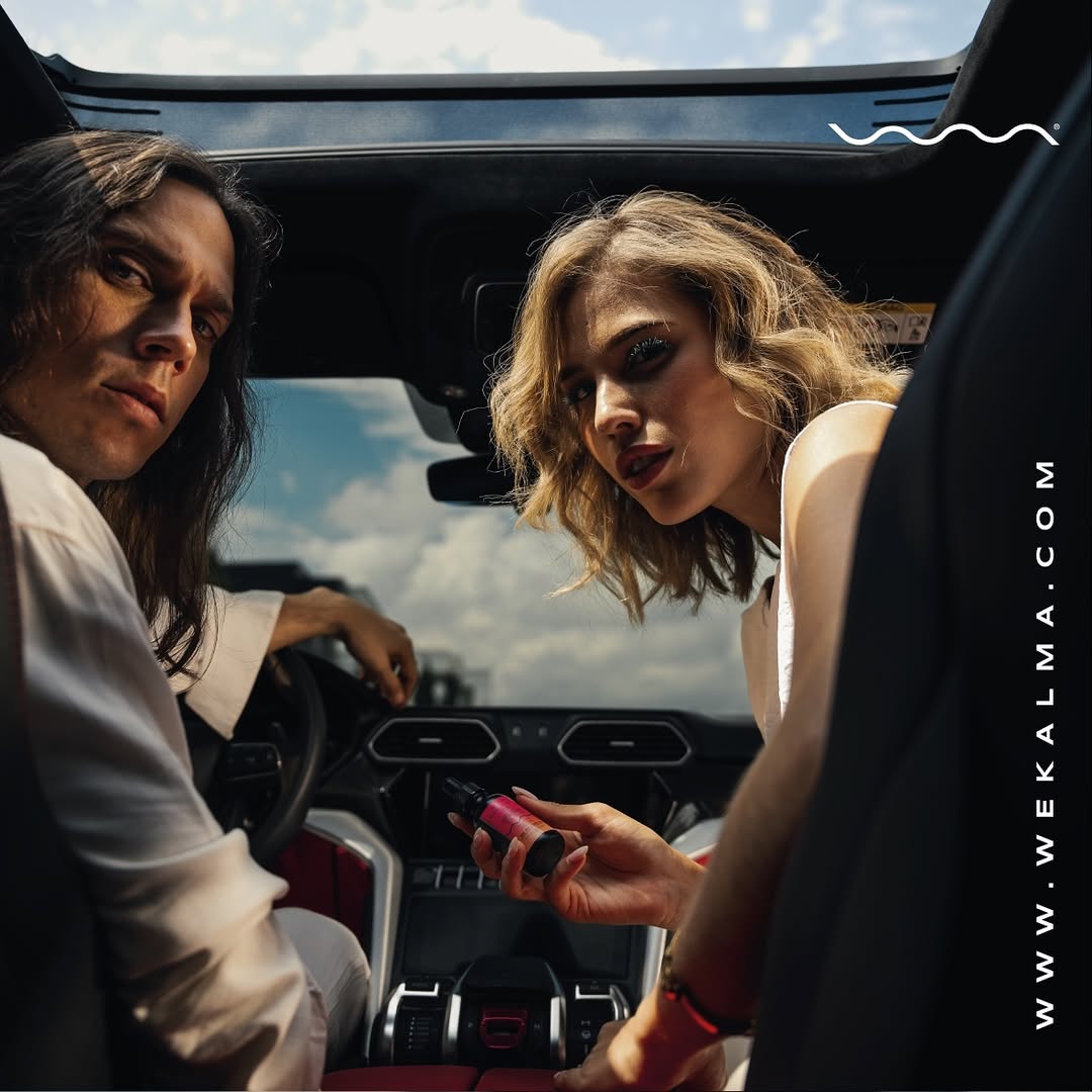 Pareja dentro de un auto sosteniendo gotas de CBD de WeKalma, representando relajación y bienestar en movimiento